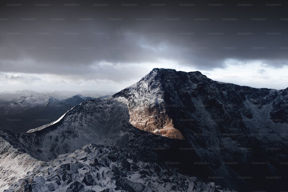 une vue du sommet d’une montagne avec un ciel nuageux