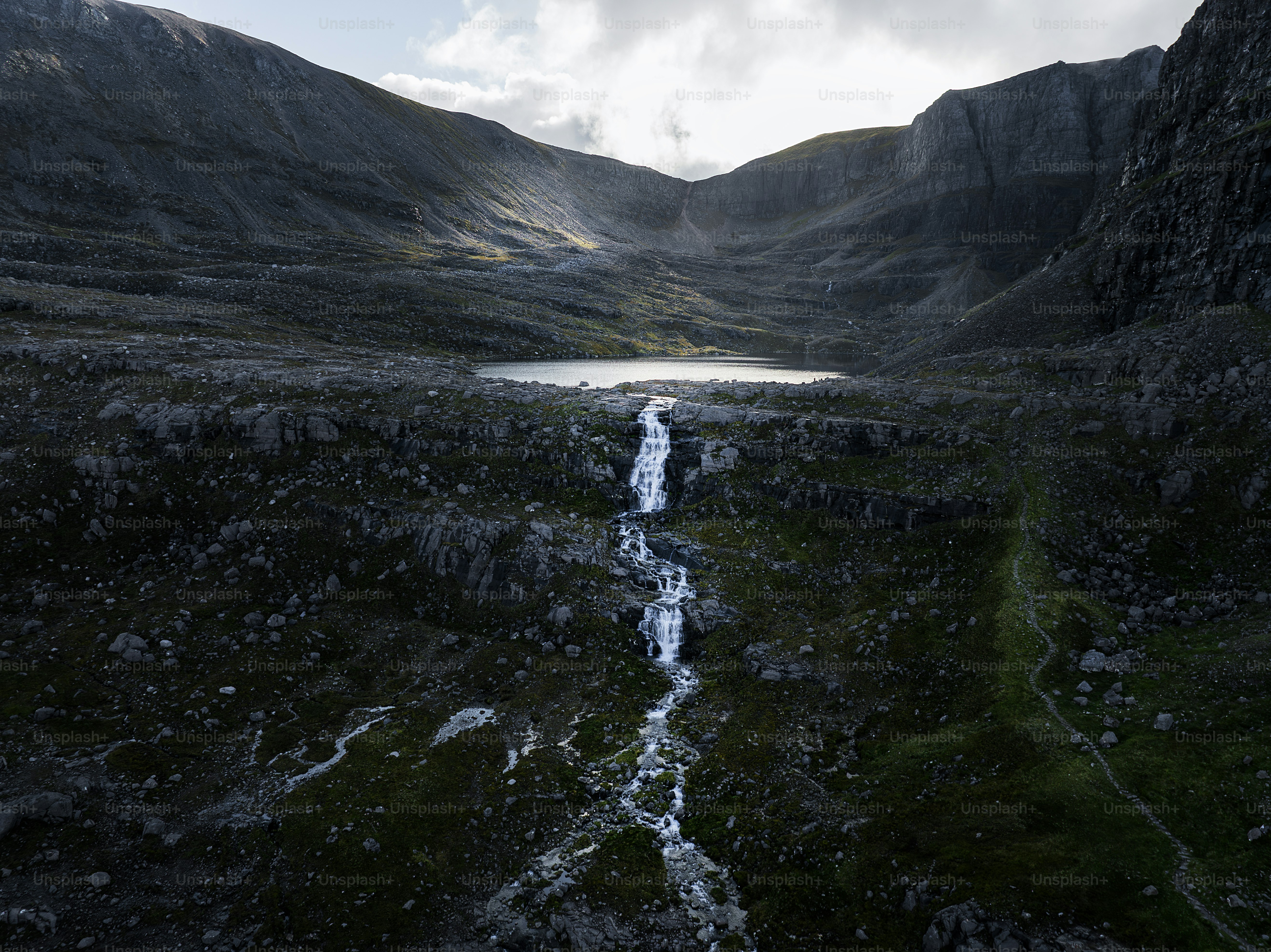 a stream running through a lush green valley