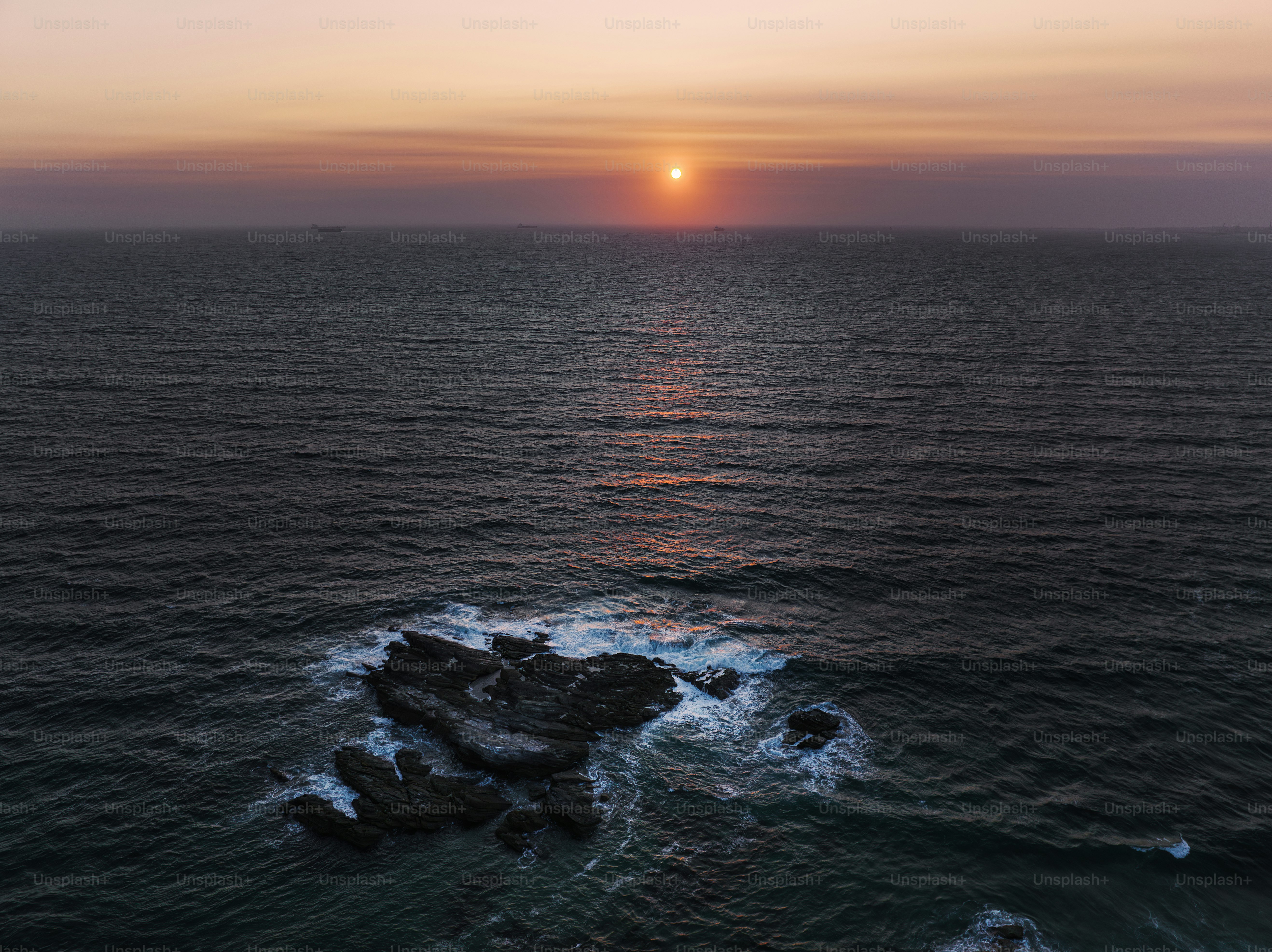 O sol está se pondo sobre o oceano com ondas