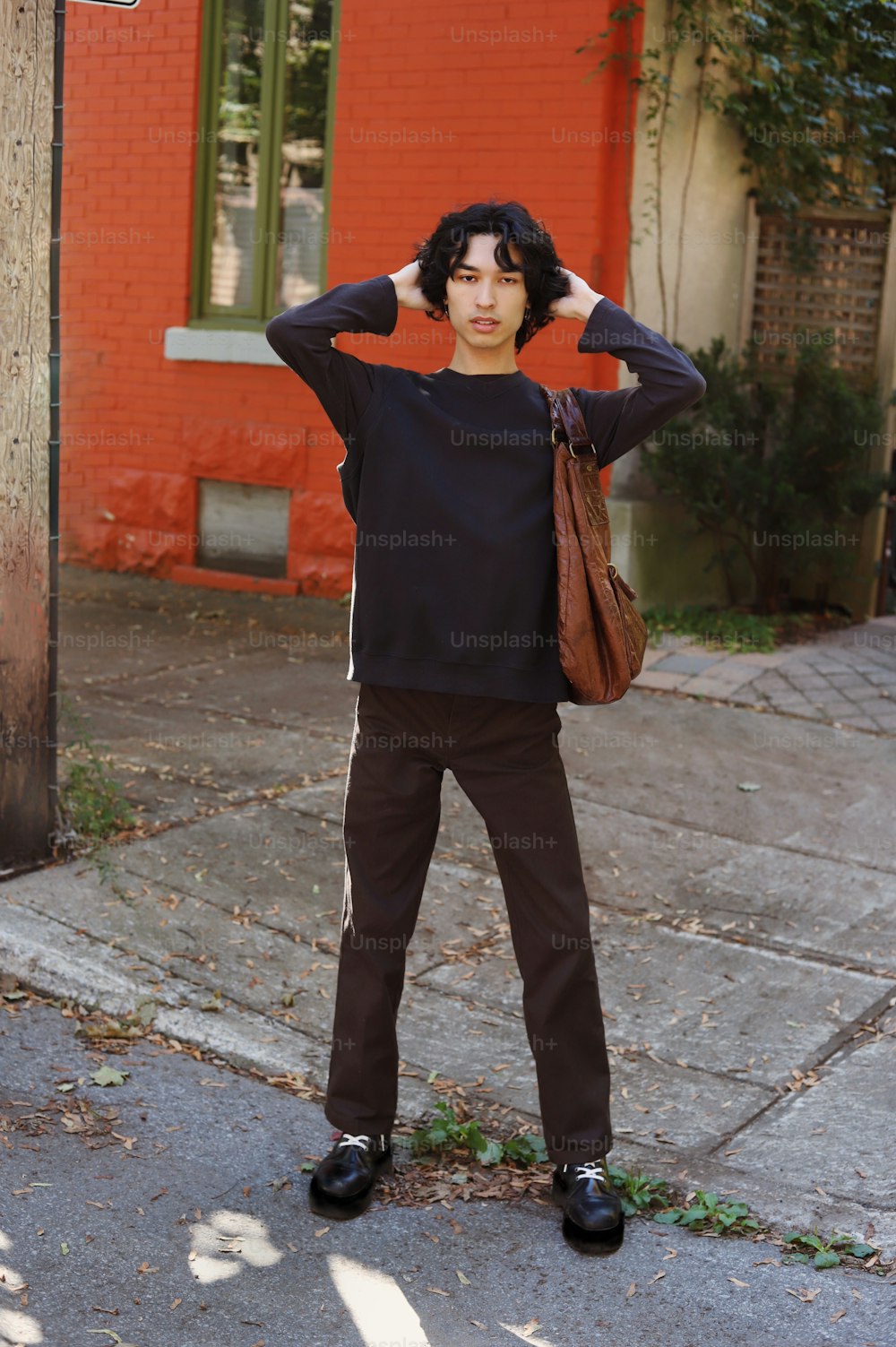 a man standing on a sidewalk with his hands on his head