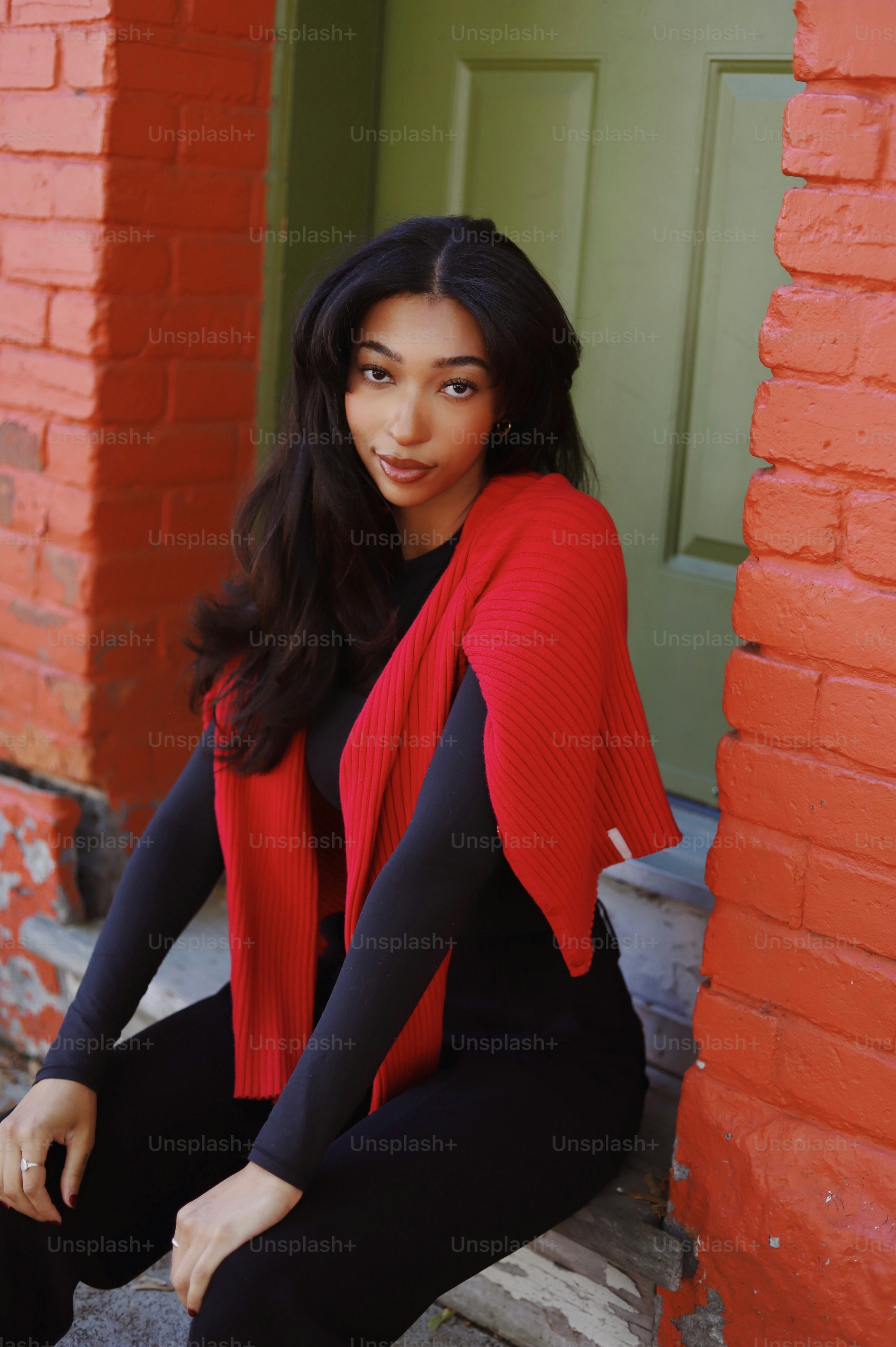 a woman sitting on a step in front of a red brick building