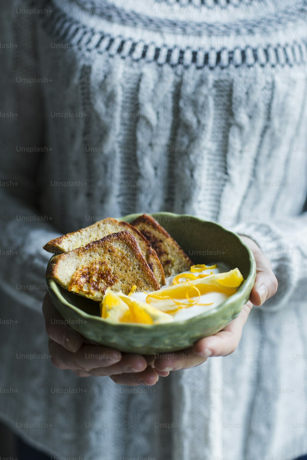 a person holding a bowl of food in their hands