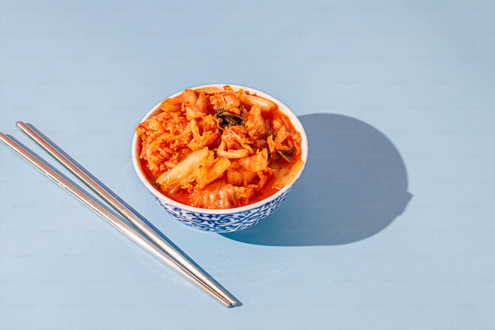 a bowl of food with chopsticks next to it