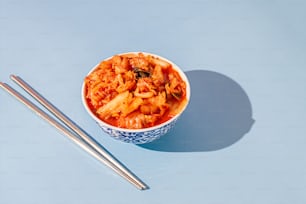 a bowl of food with chopsticks next to it