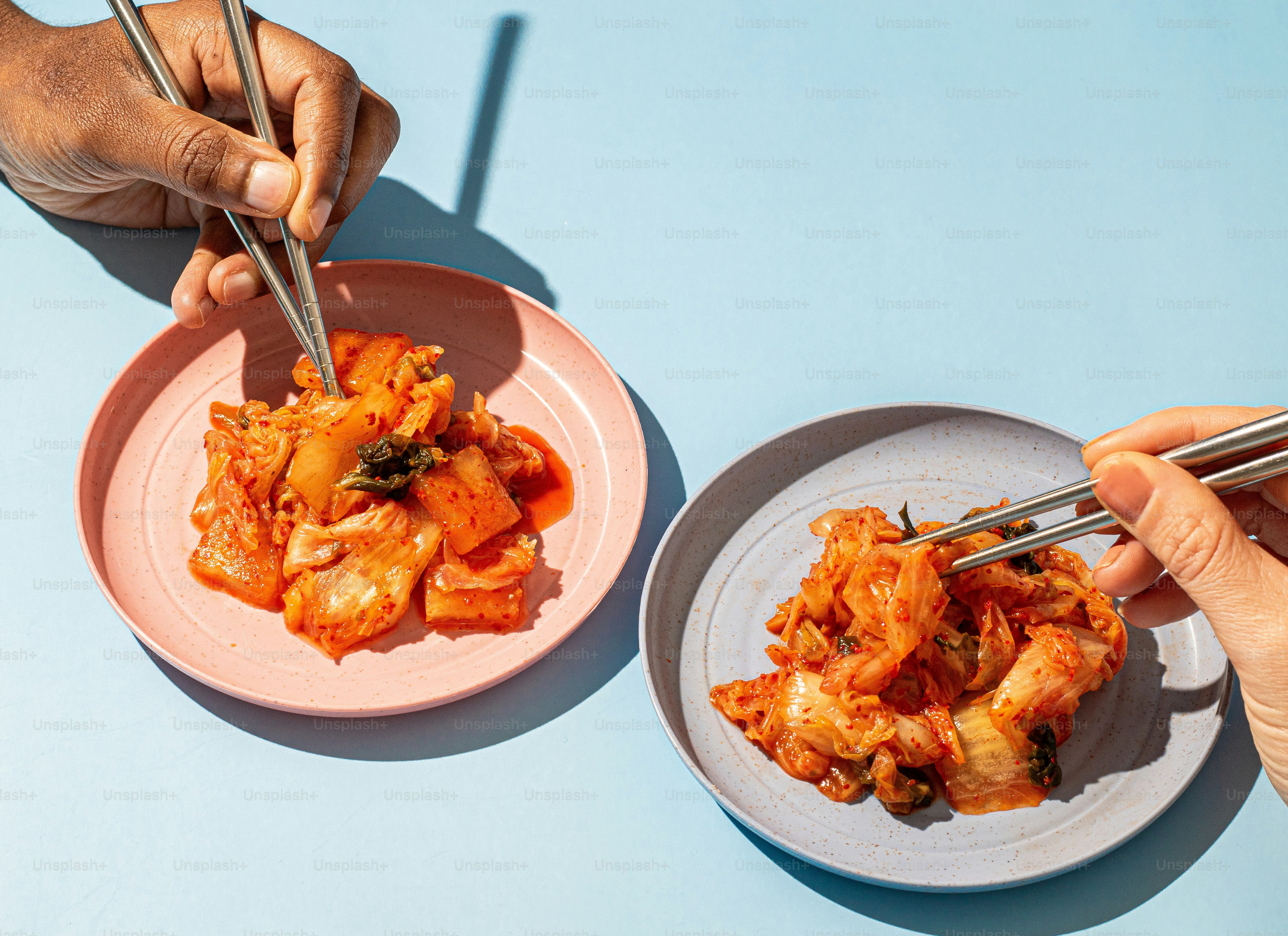 a person holding chopsticks over a plate of food