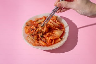 a person holding a fork in a bowl of food