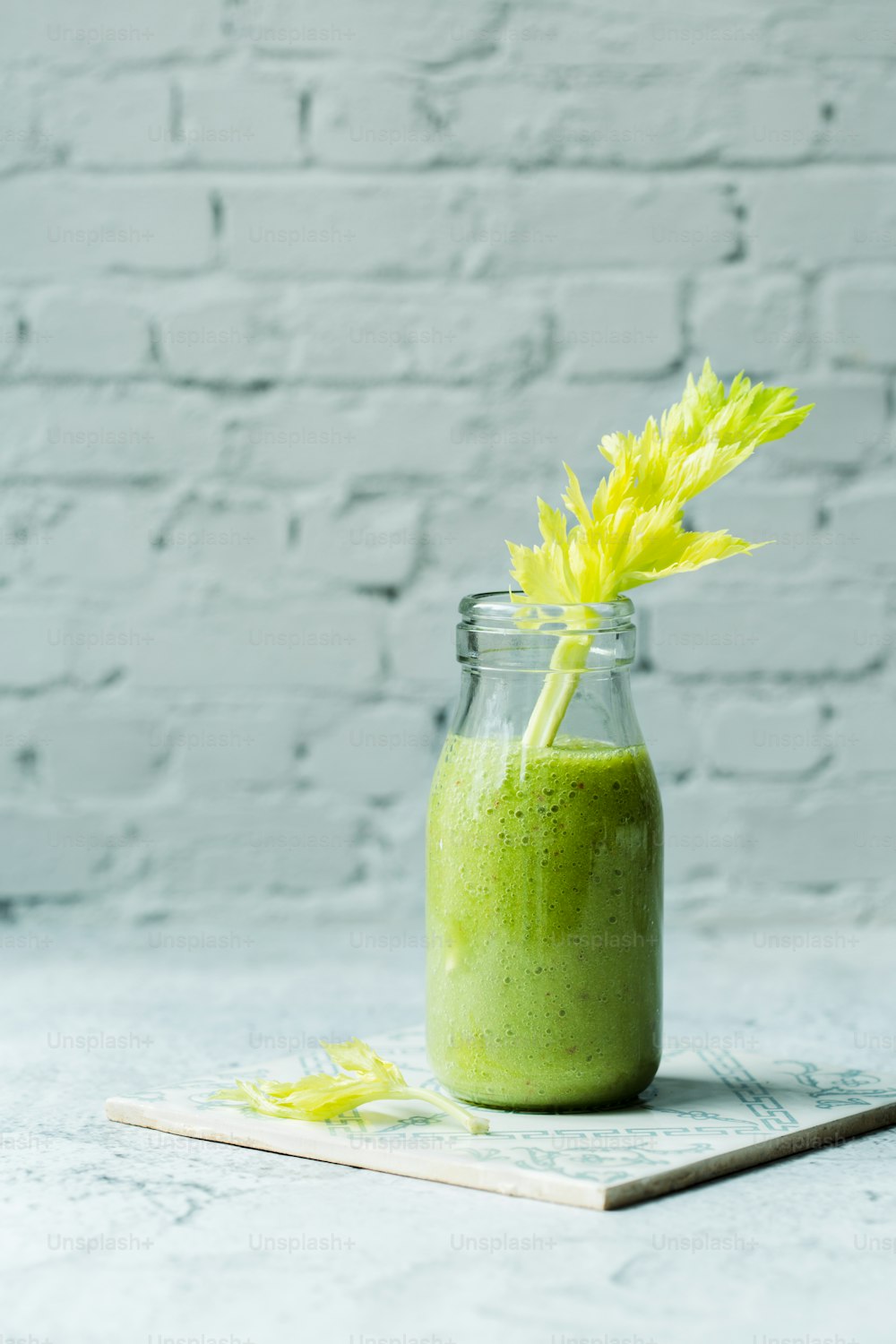a green smoothie in a glass jar with a yellow flower