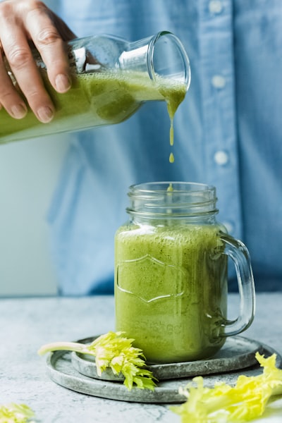 Jus de céleri vert versé dans un bocal en verre - Pressage à froid préservant la phycocyanine | Joy Juice
