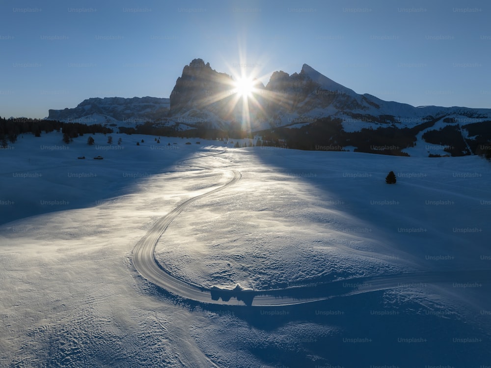 the sun shines brightly over a snowy landscape