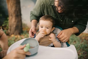 a baby sitting in a high chair eating food