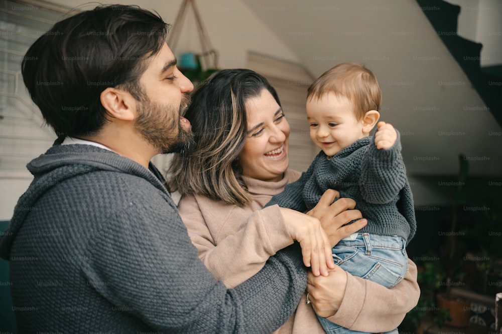 a man and woman holding a baby in their arms