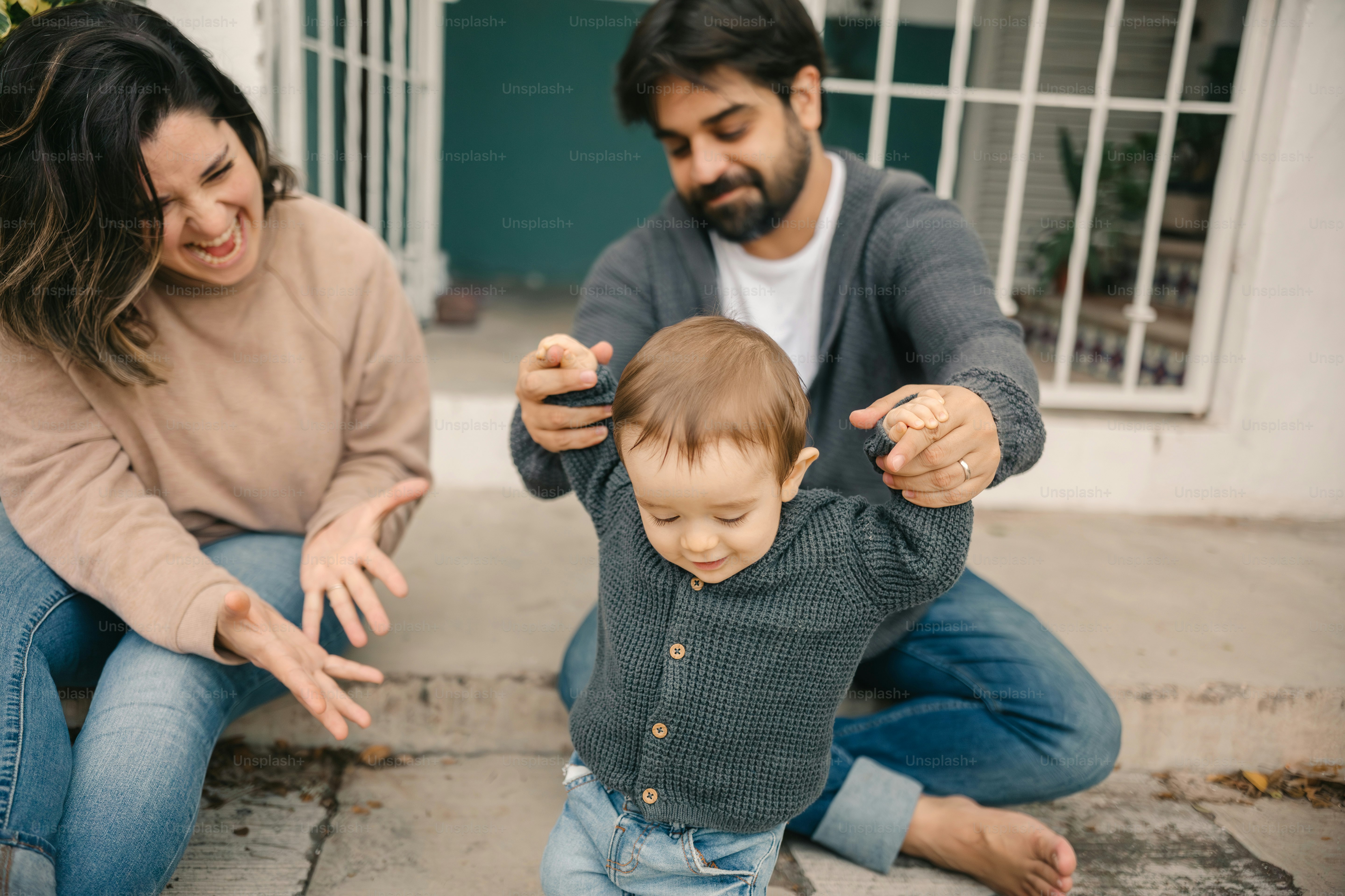 a man and woman sitting on the ground with a baby