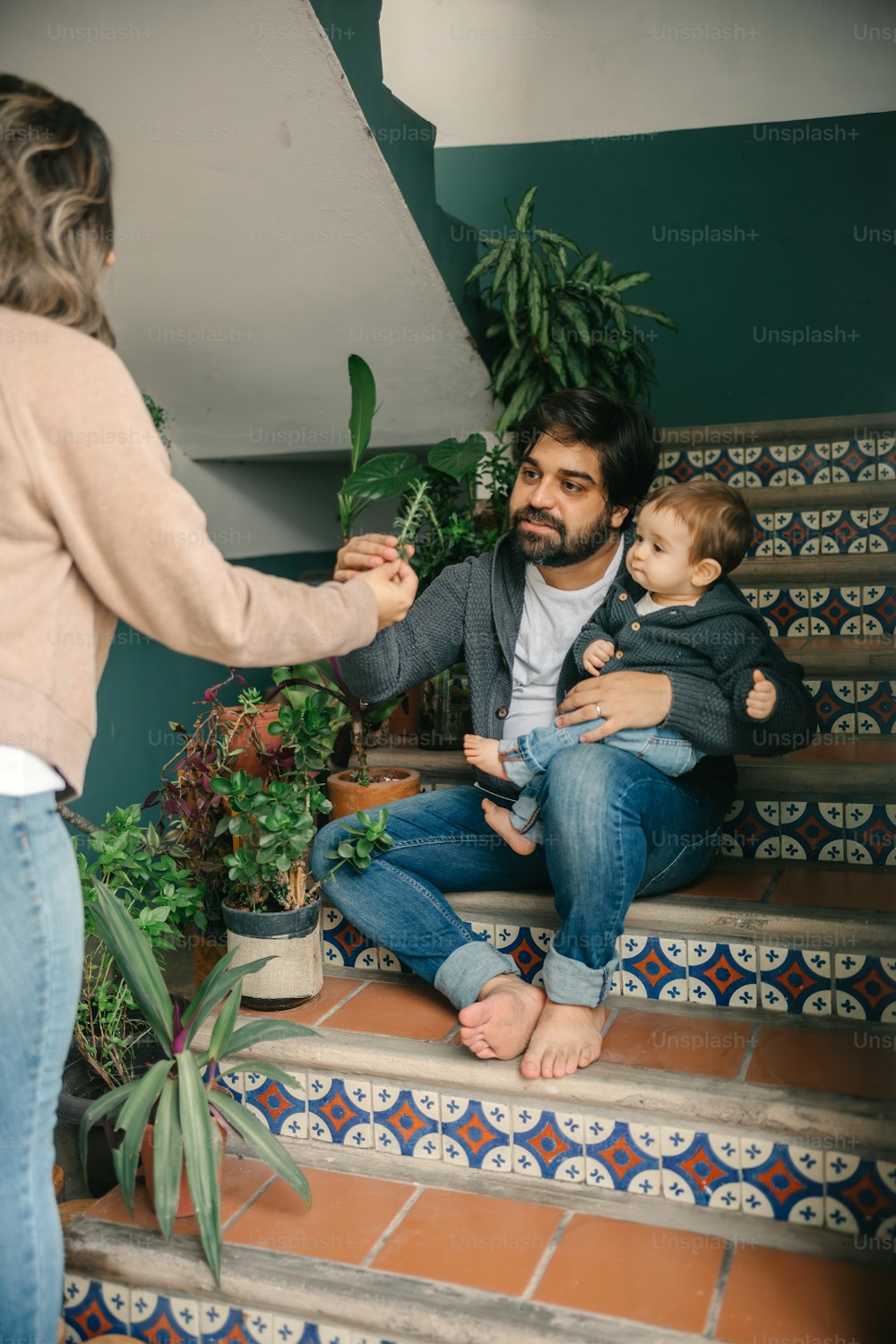 a man holding a baby on the steps of a house