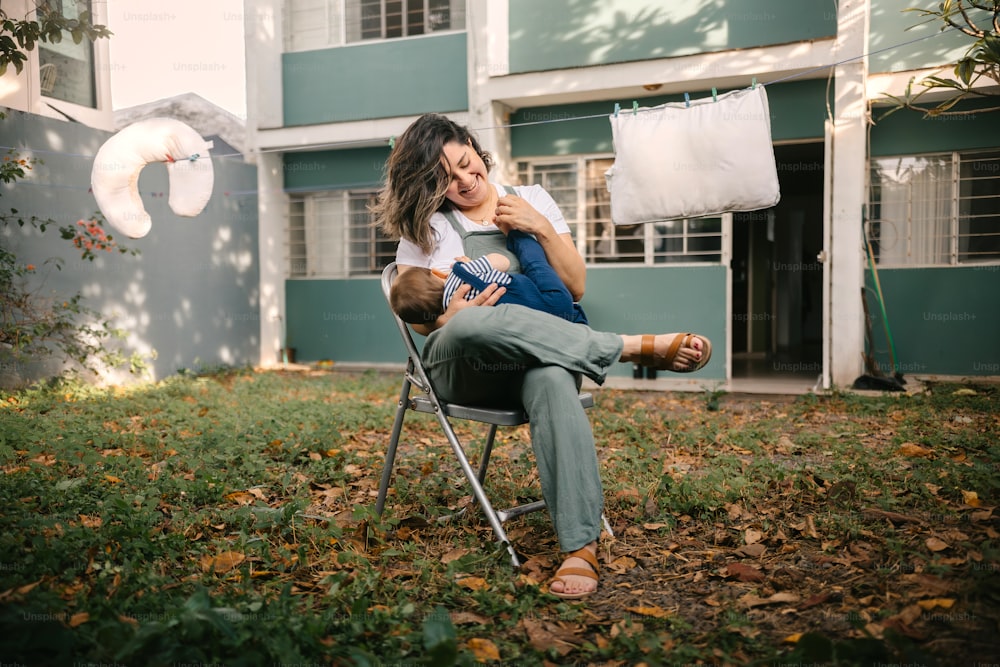 a woman sitting in a chair holding a baby