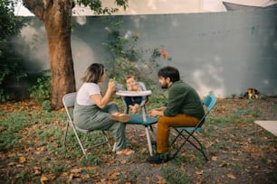 a man and woman sitting at a table with a baby