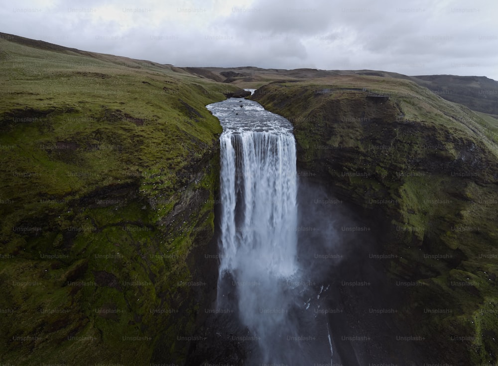 an aerial view of a waterfall in the middle of a field