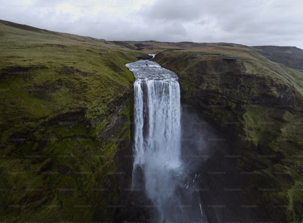 an aerial view of a waterfall in the middle of a field