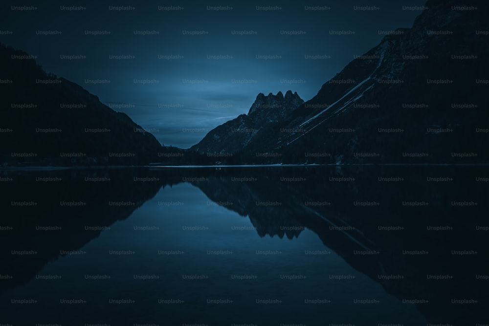 a lake with mountains in the background at night
