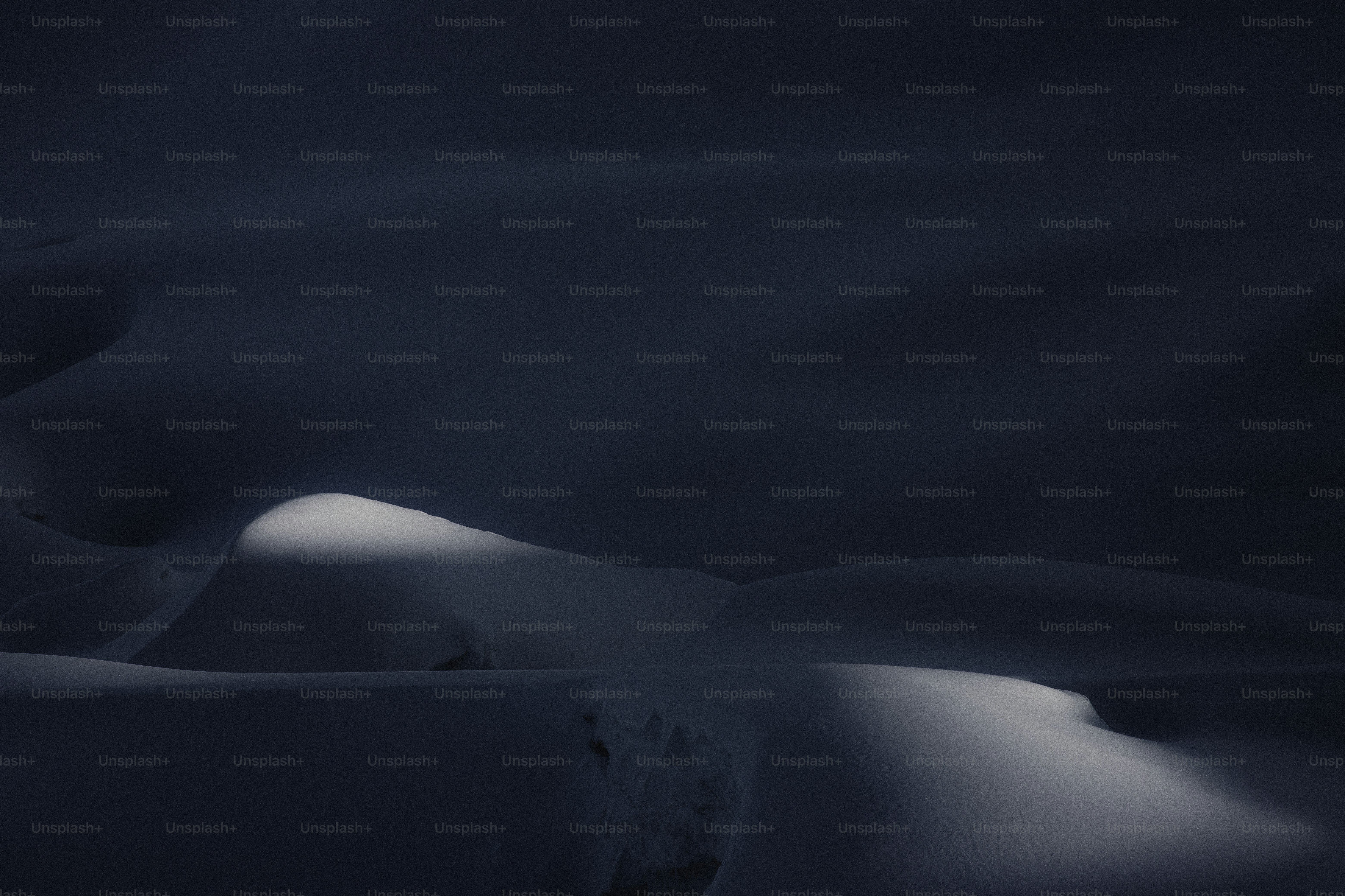 Una foto scura di una montagna innevata