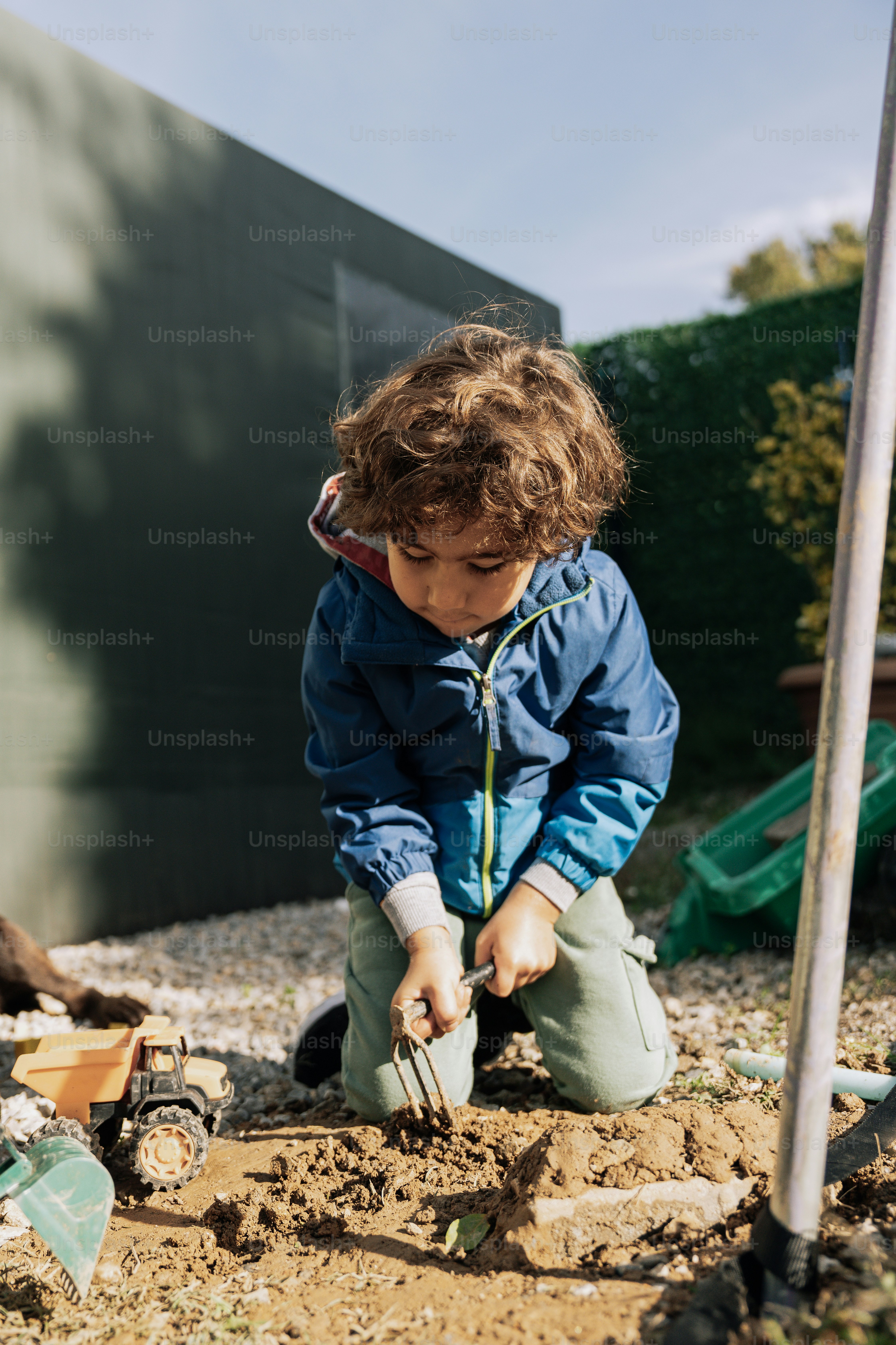 A little boy digging in the dirt with a shovel photo – Boy Image on ...