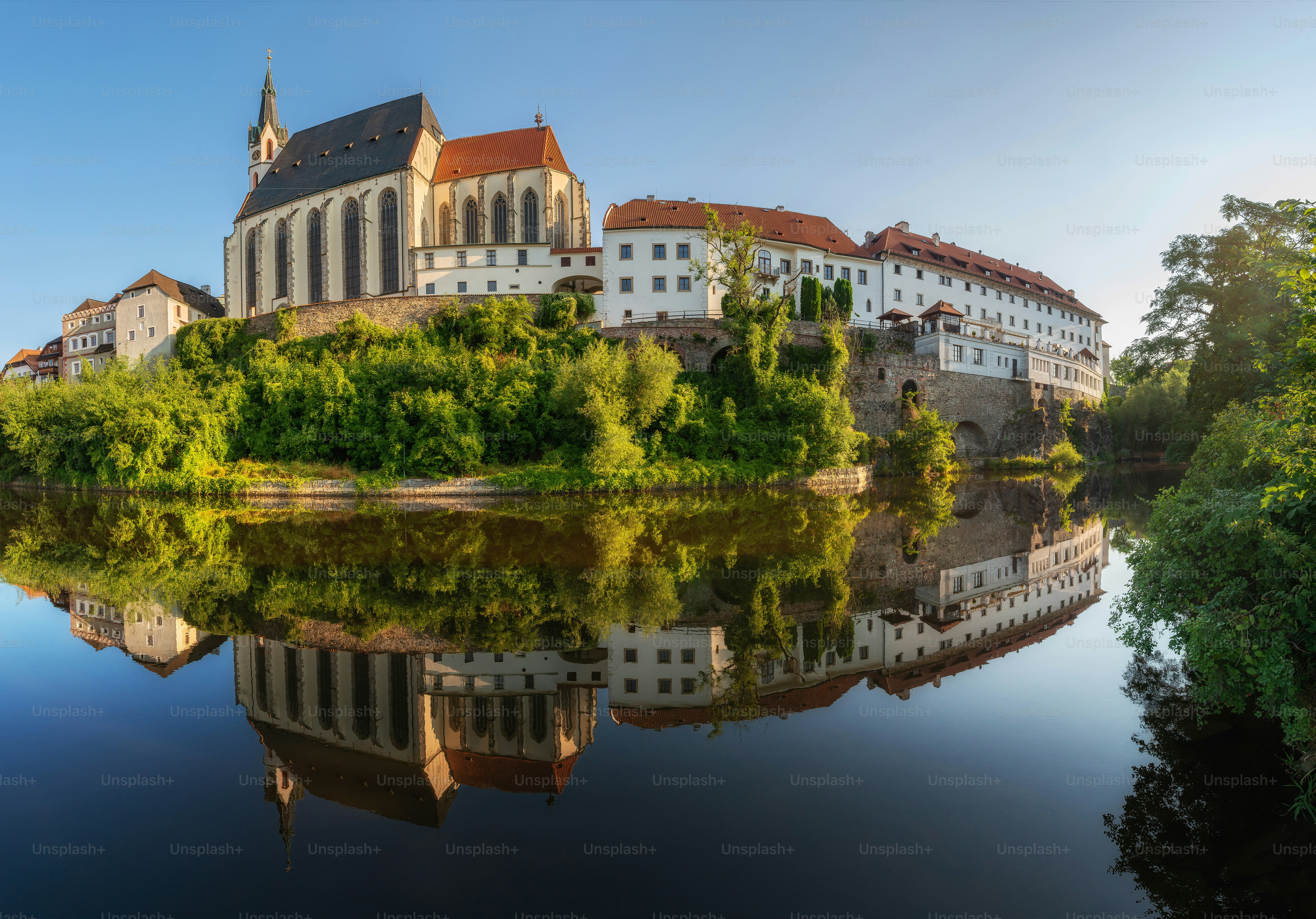 a large building sitting on top of a hill next to a river