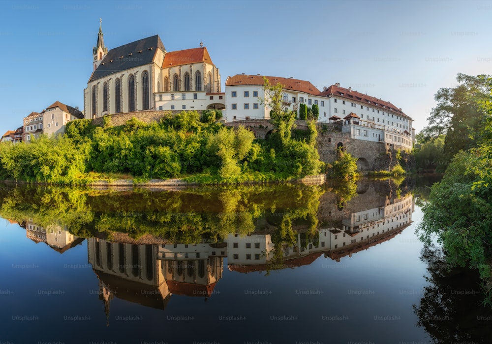 a large building sitting on top of a hill next to a river