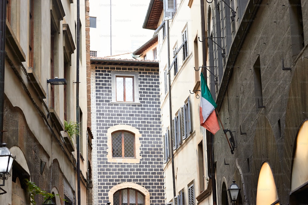 a narrow alleyway with a clock tower in the background