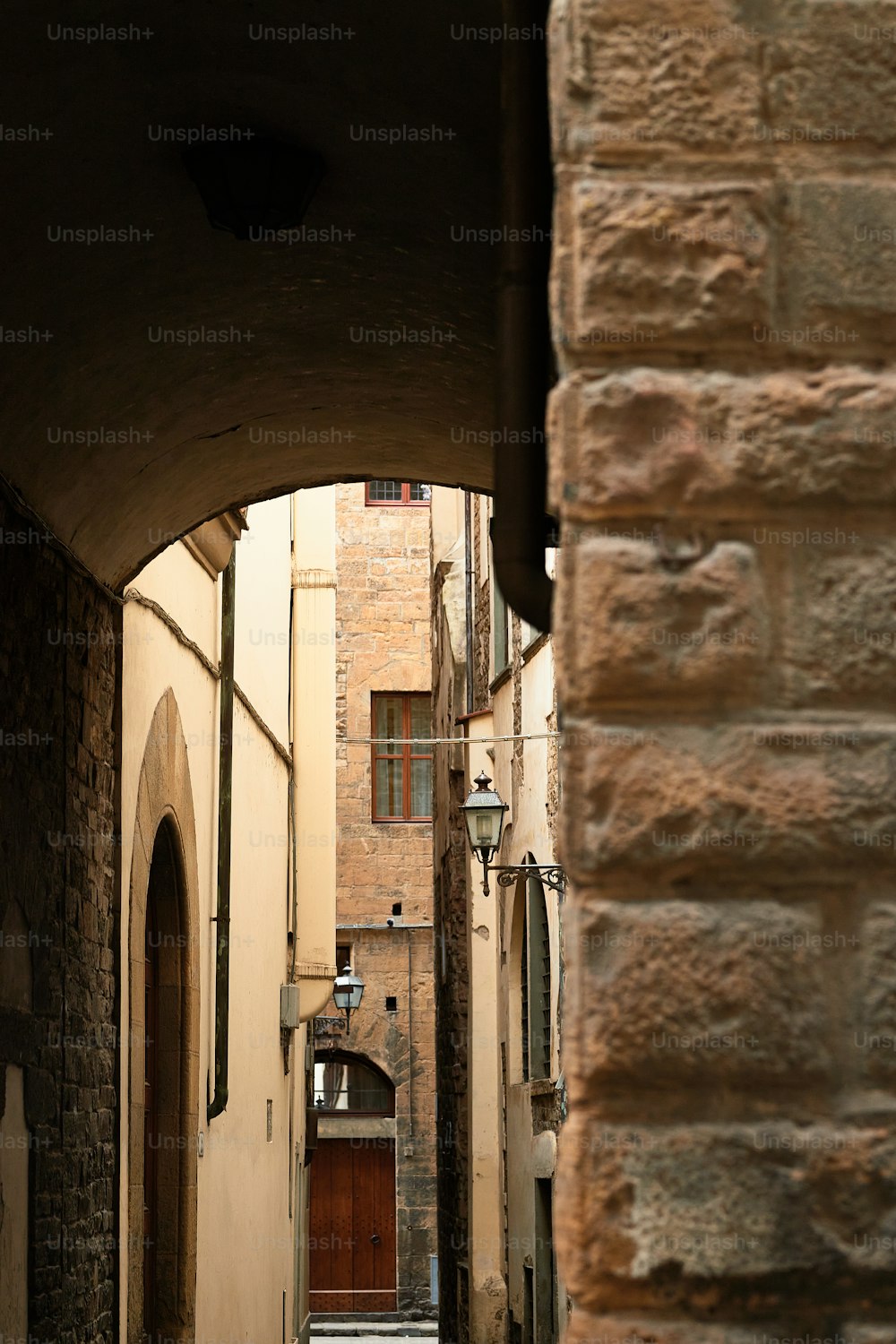 a narrow alley way with a brick building in the background