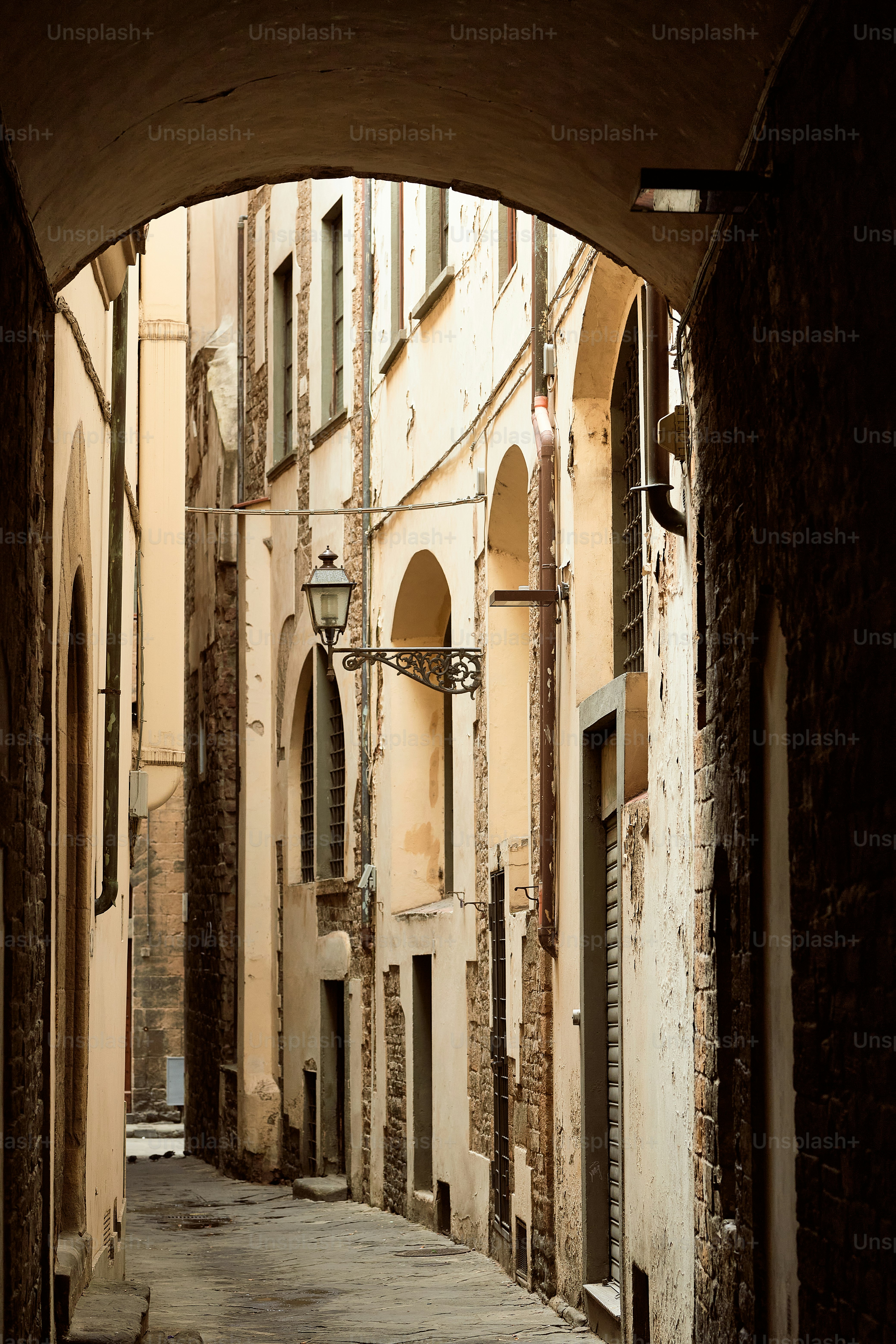 a narrow alley way with a clock on the wall