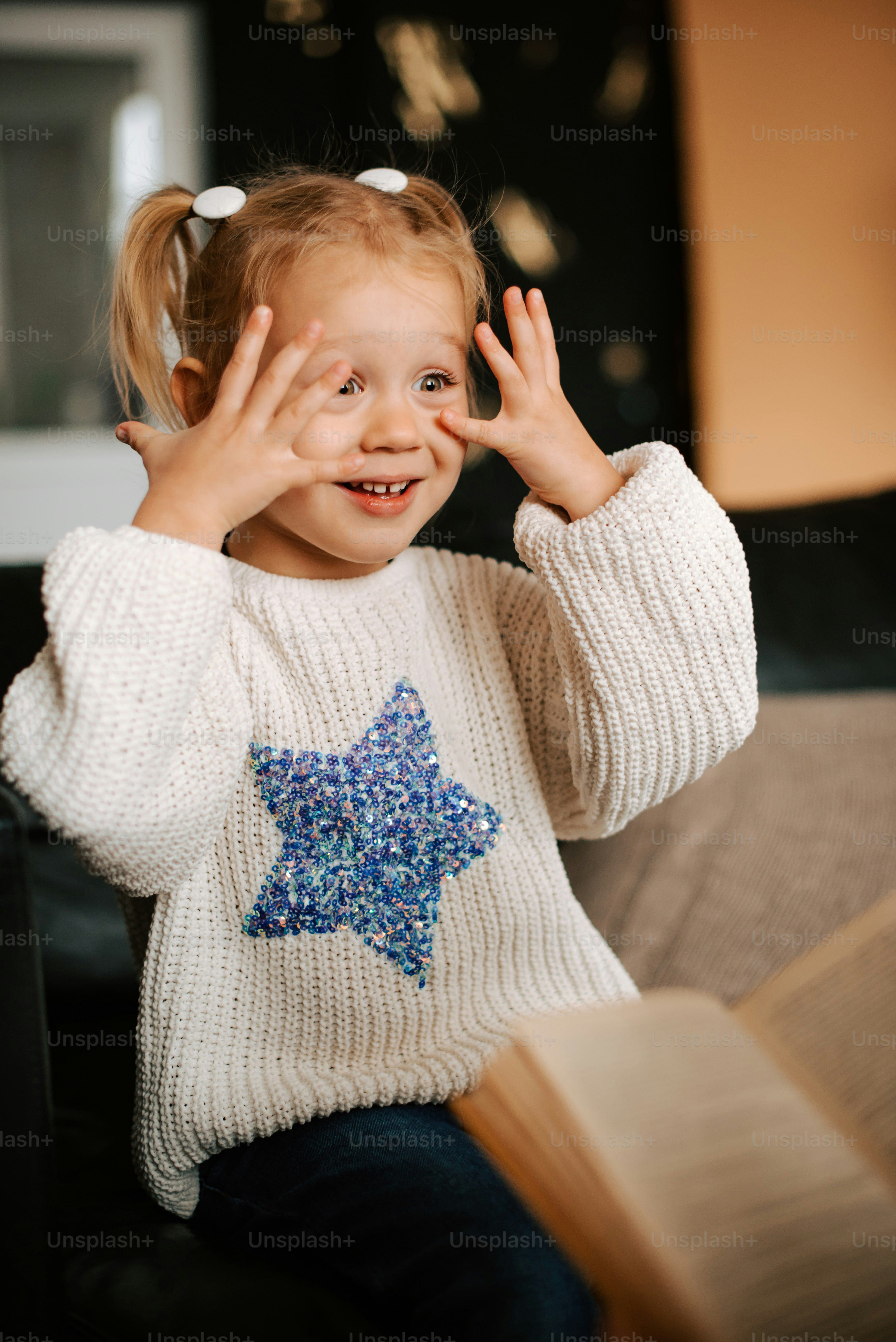 a little girl that is sitting down with a book