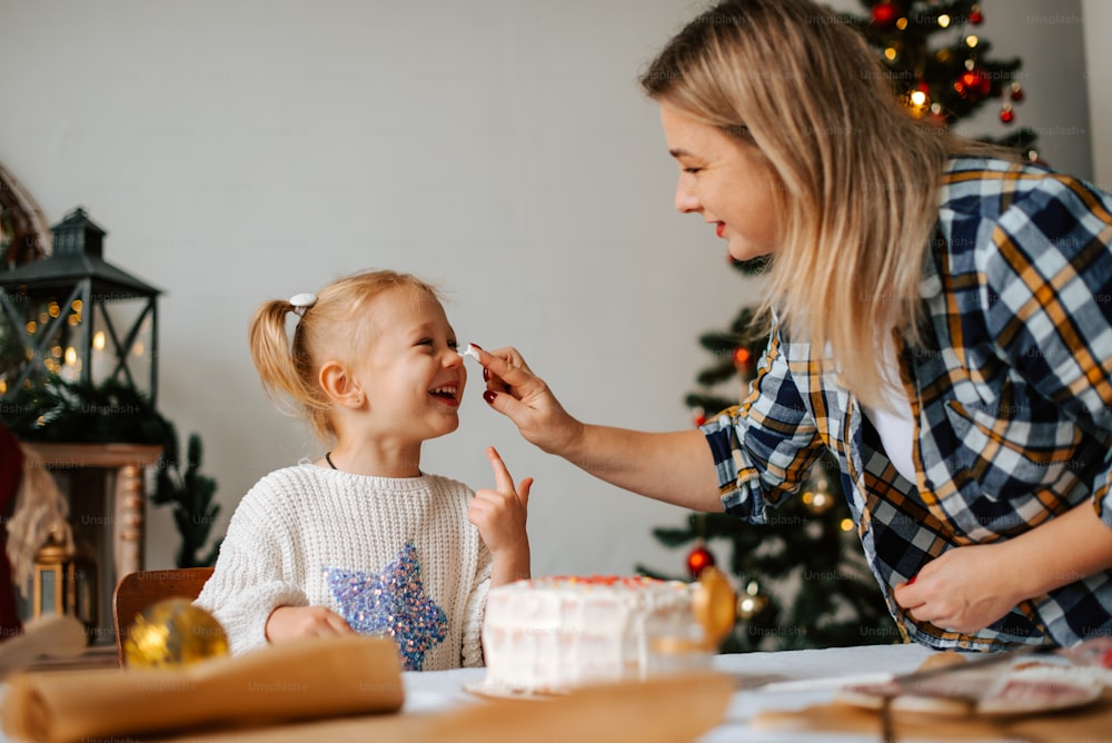 a woman feeding a little girl a piece of cake