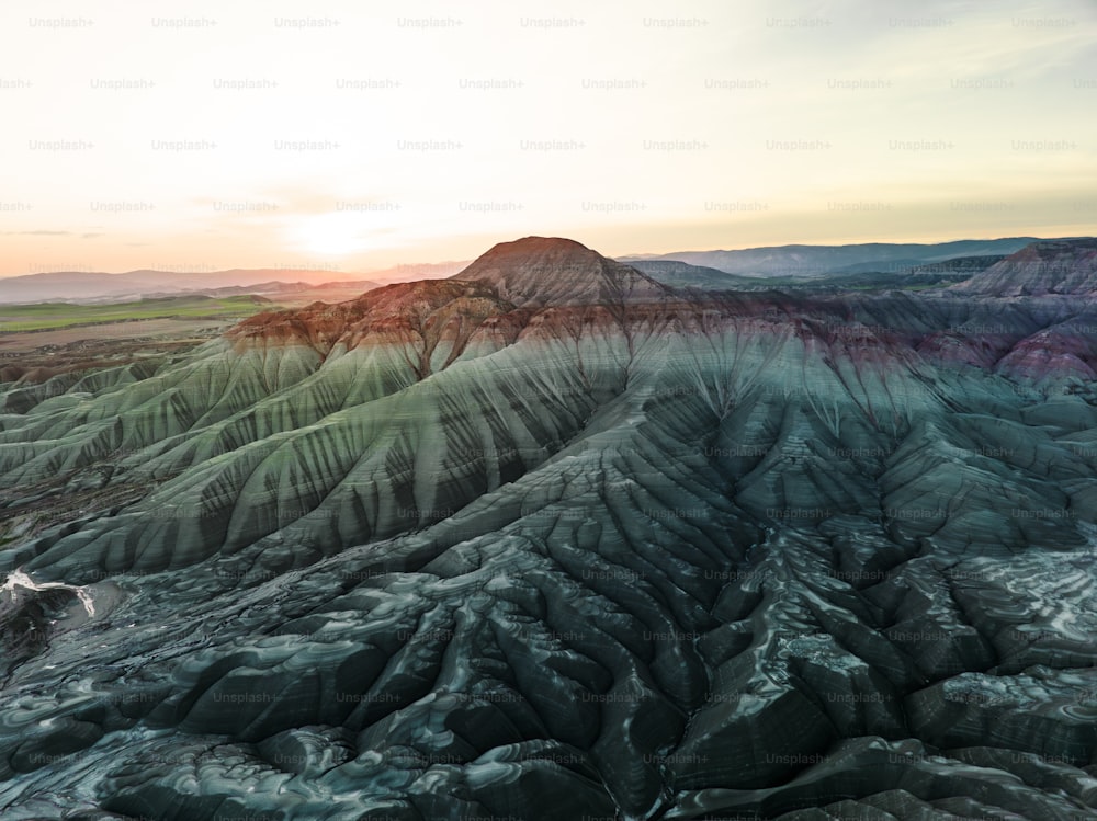 an aerial view of a mountain range at sunset