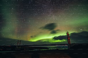 a bridge that has a green light in the sky