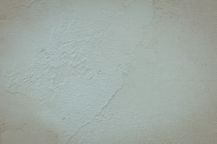 a white stucco wall with a black clock on it