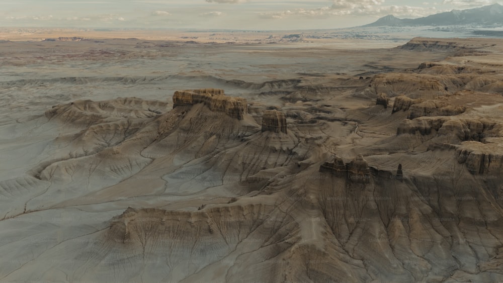 an aerial view of a desert landscape with mountains in the background