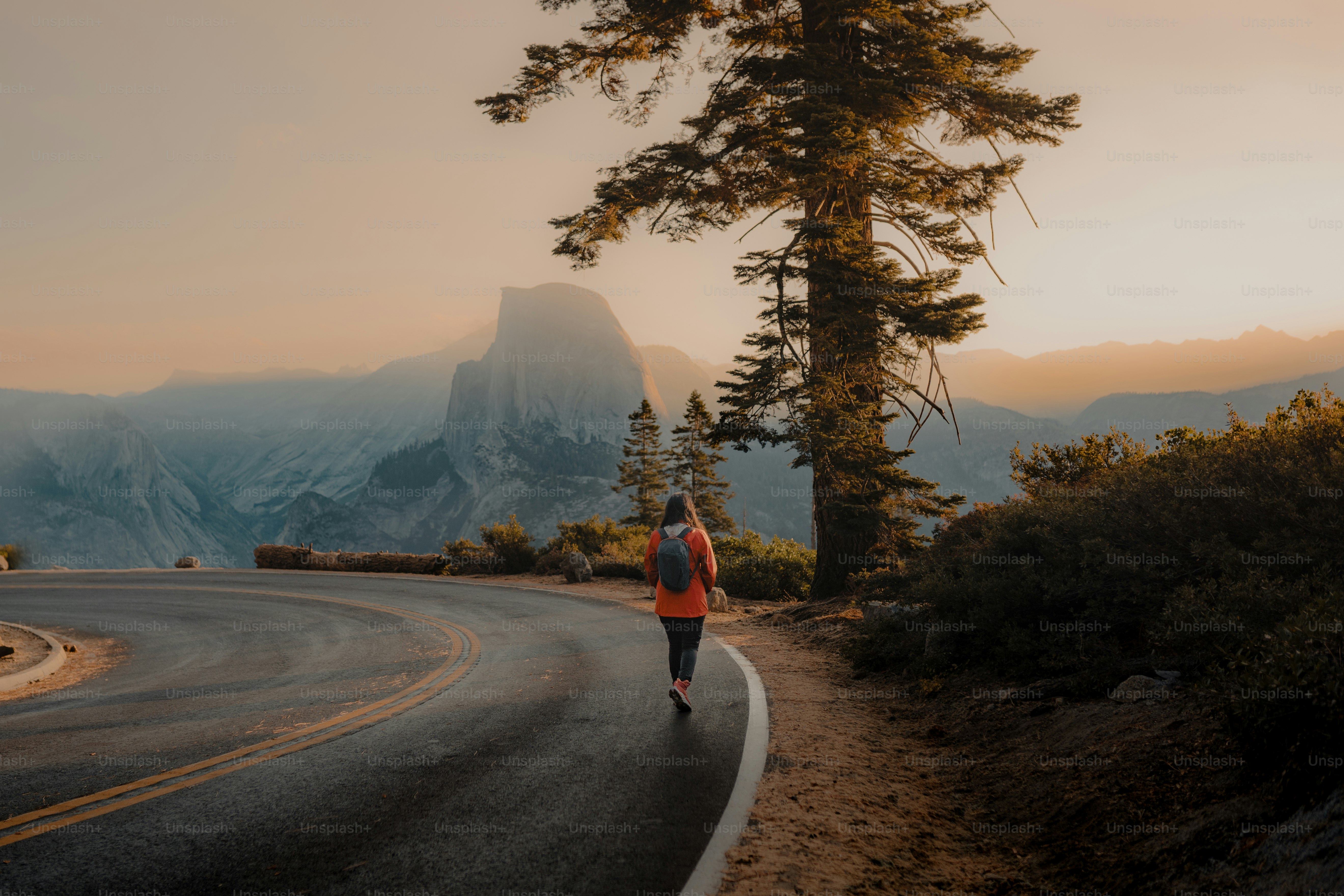 a woman running down a road in the mountains