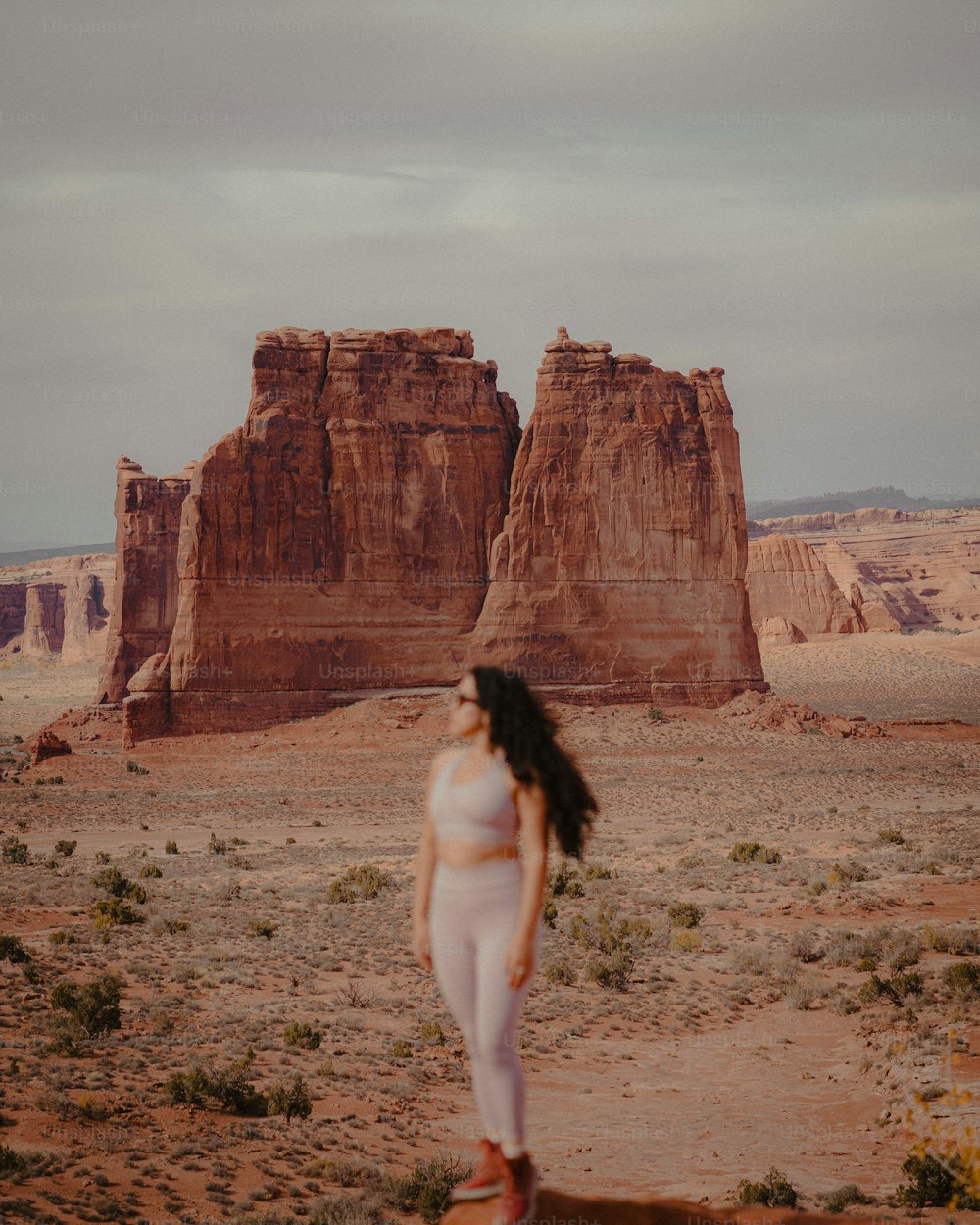 une femme en tenue blanche debout dans le désert