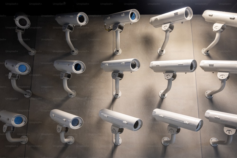 a bunch of white security cameras on a wall