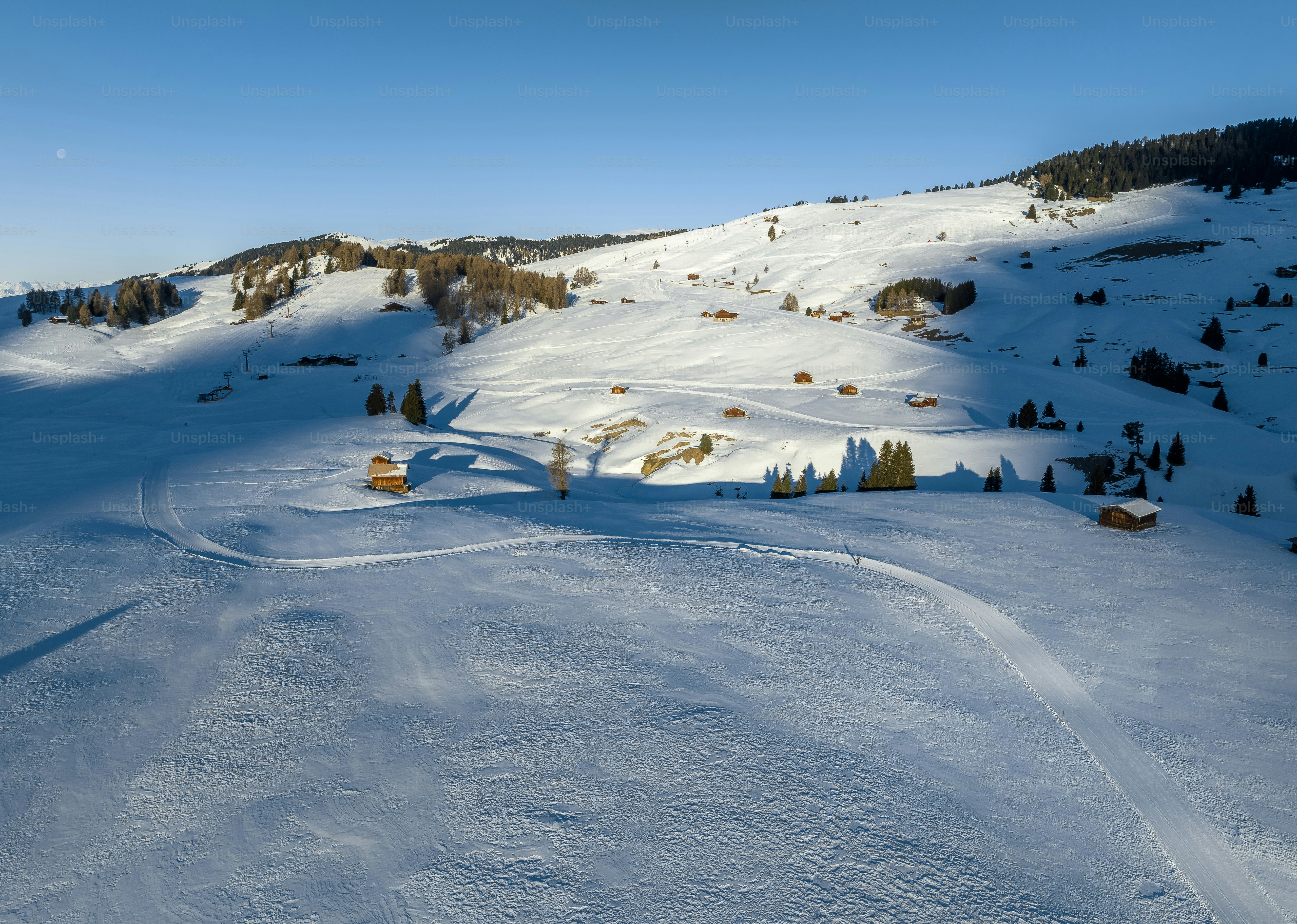 a snow covered mountain with a small cabin on top of it