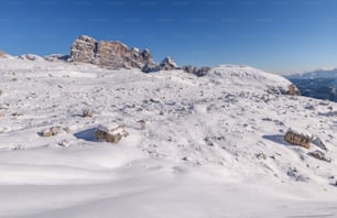 a snow covered mountain with rocks and a sky background