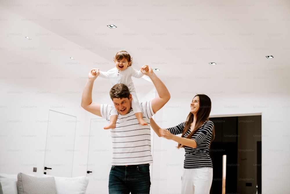 a man holding a little girl on his shoulders