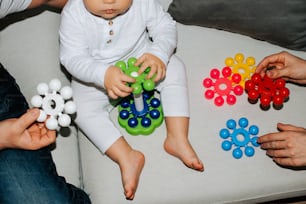 a baby sitting on a couch playing with toys