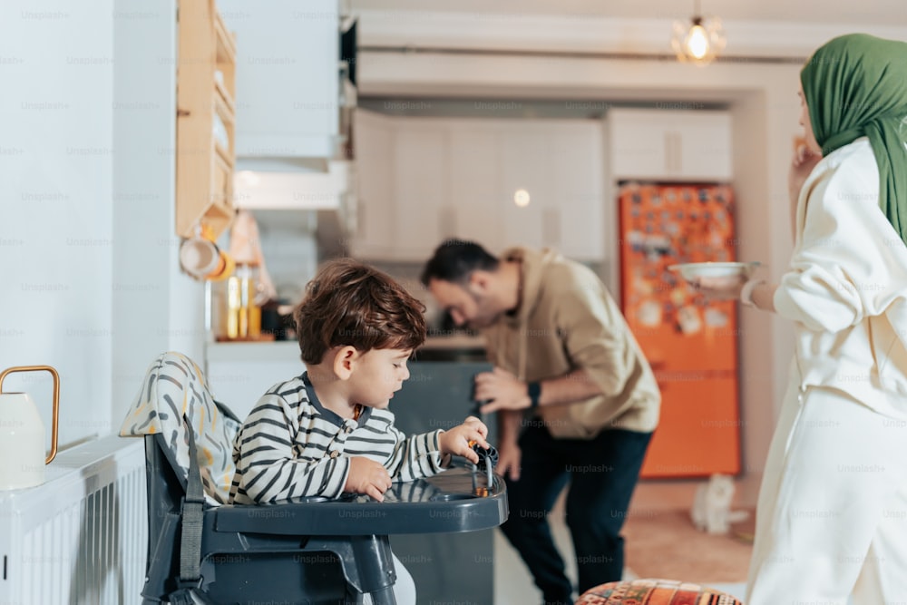 a young boy sitting in a high chair next to a woman