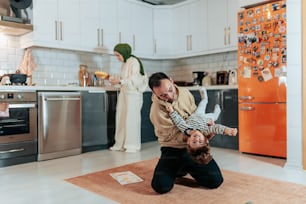 a man holding a child in a kitchen