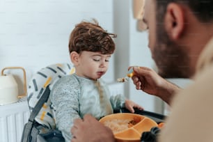 a man feeding a child a spoon of food