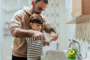a man and a child are brushing their teeth