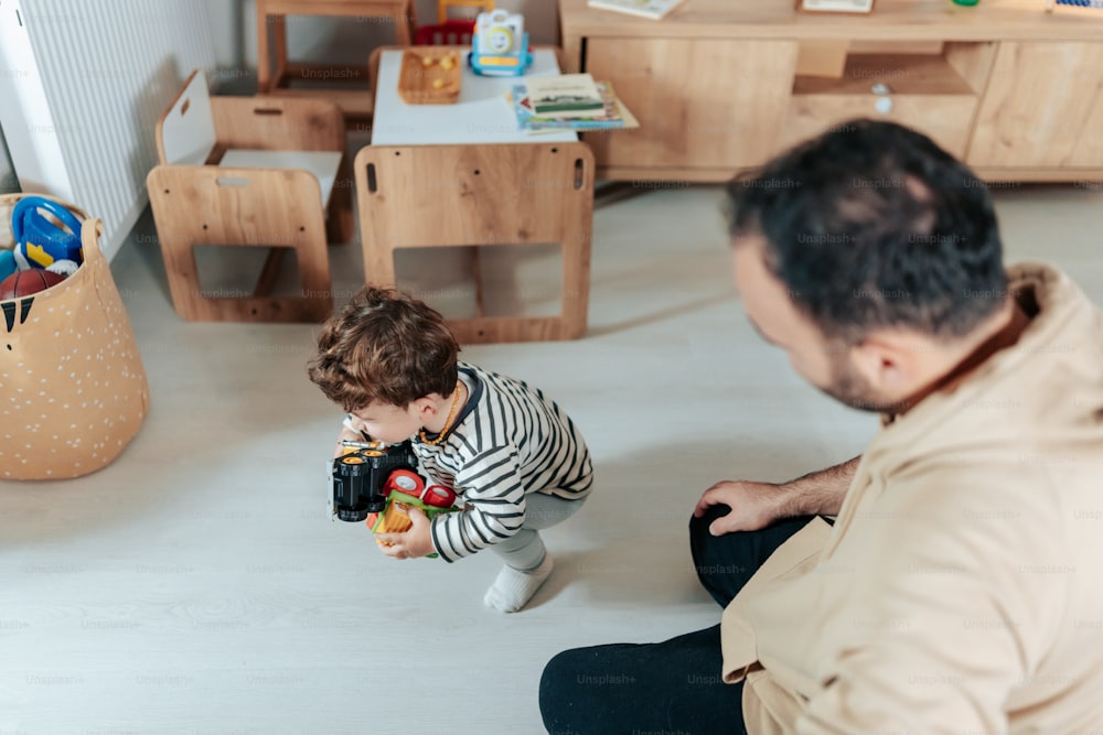 a man sitting on the floor playing with a toddler