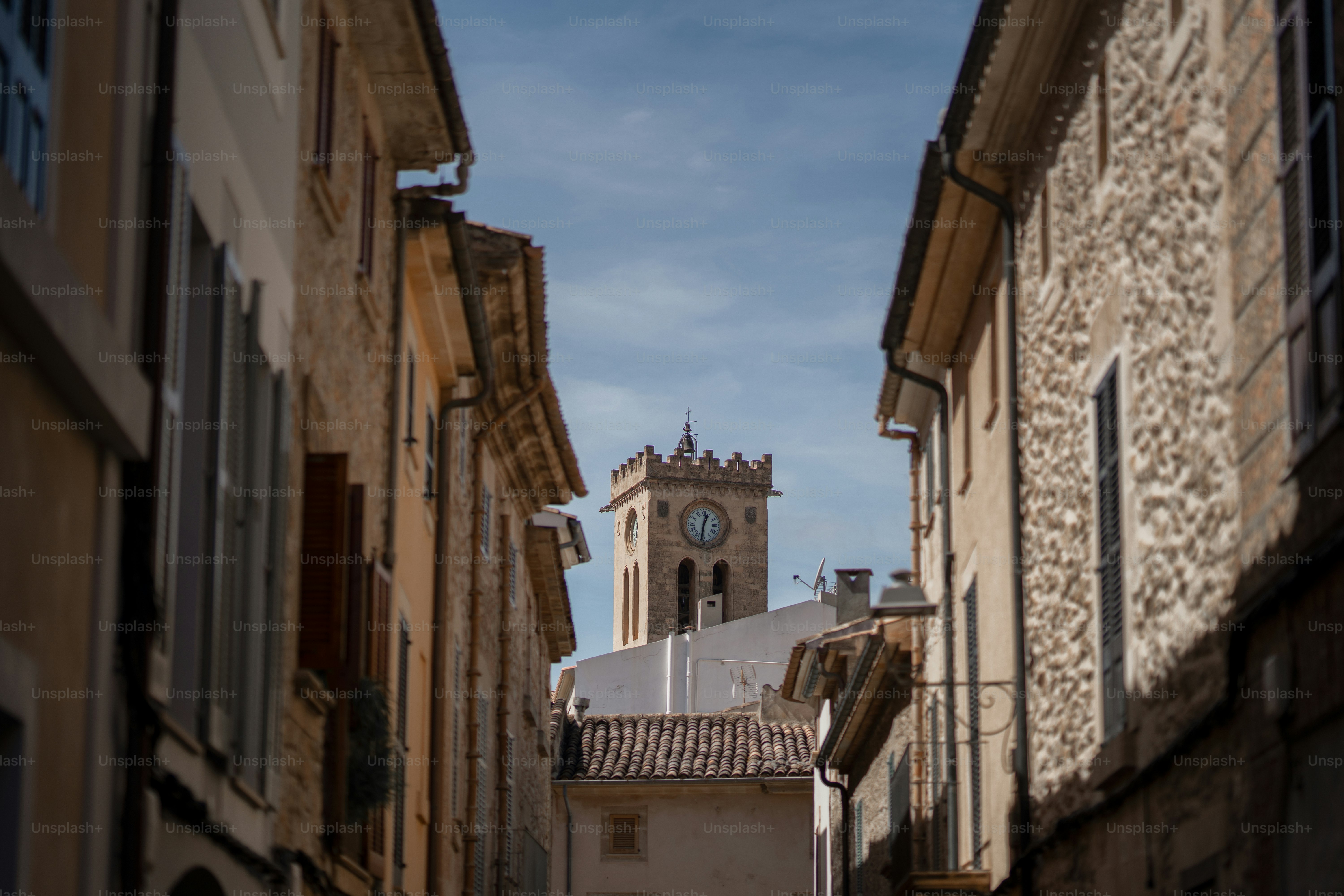 uma rua estreita com uma torre do relógio ao longe