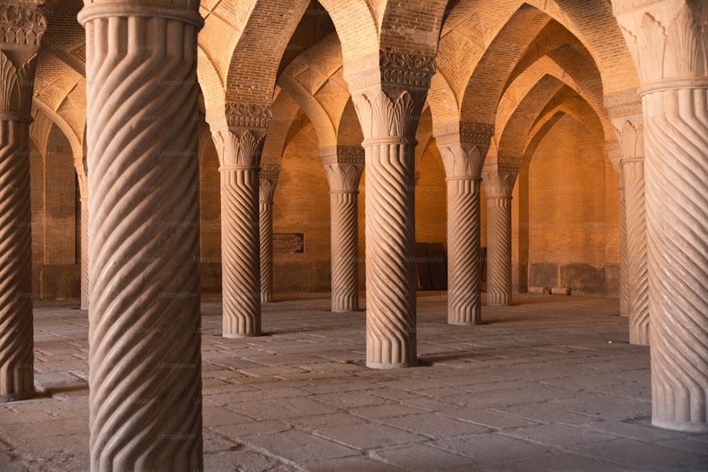 a large room with columns and a clock on the wall