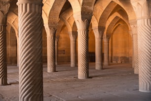 a large room with columns and a clock on the wall